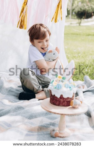 sstkEaster Easter celebration, Child in nature with Easter cake and eggs and Easter decor