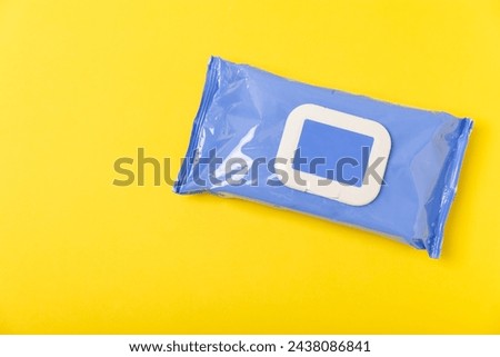 Pack of wet wipes on a yellow background. An open pack of hand and body wipes. Mockup. A clean packet of wet wipes. Design. Place for text. Copy space.