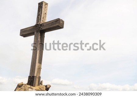 cross made of stone with blue sky background.