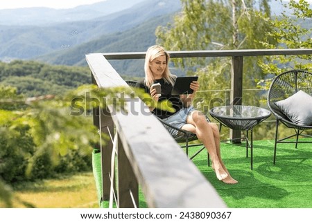 inspirational image of stylish female drinks and works with laptop, sunset light and mountain view. freelance woman works outside