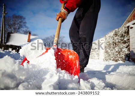 Man with snow shovel cleans sidewalks in winter. Winter time. Latvia. Europe.  Royalty-Free Stock Photo #243809152