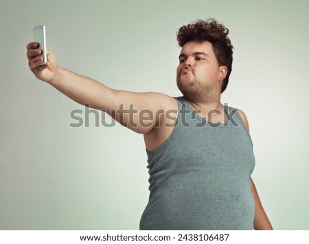 Selfie, phone and plus size man in studio posing with casual, trendy and cool outfit with stomach. Cellphone, pout and overweight male person with photography picture isolated by gray background.