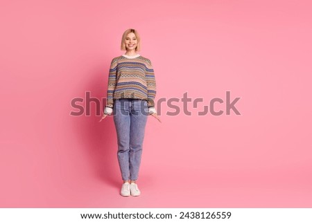 Full length photo of adorable gorgeous girl dressed print sweater jeans trousers stand like doll isolated on pink color background