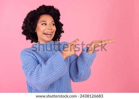 Photo portrait of lovely young lady point hold look empty space wear trendy blue knitwear garment isolated on pink color background