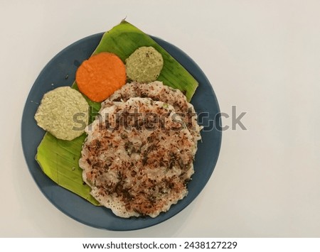 A closeup picture of a south Indian Breakfast called onion uttapam against a white background.