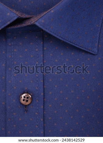 Close-up of the button placket on a blue men's shirt with an abstract pattern