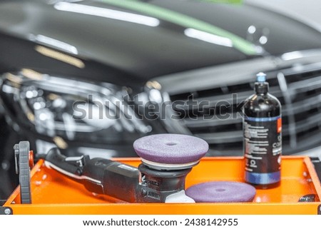 Detail to car detailing polisher and special wax from removing a scratches with luxury car on the background, car detailing concept Royalty-Free Stock Photo #2438142955