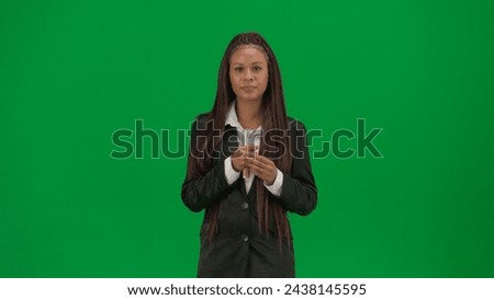 Female reporter isolated on chroma key green screen background. African American woman news host in suit with microphone.