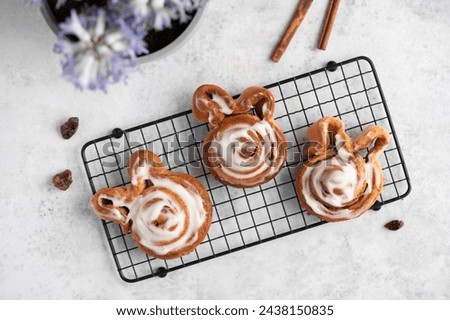 Fresh homemade Cinnamon Rolls pastries covered in cream cheese icing for Easter. Easter festive food. Cinnamon roll bunny. Food for children.