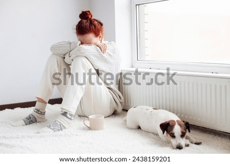 Unhappy Woman sitting on floor at Home, thinking about Problems, Upset Girl feeling Lonely and Sad, psychological and mental troubles, suffering from bad relationship or break up Royalty-Free Stock Photo #2438159201