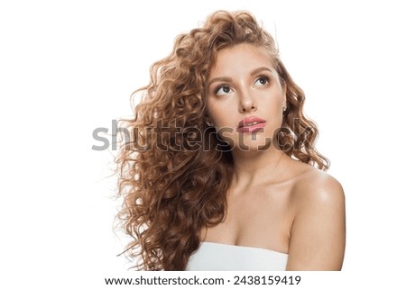 Pretty fashion model with frizzy hair, natural makeup and healthy clean skin posing on white background. Skincare, haircare and cosmetology concept