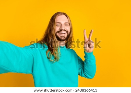 Portrait of nice cheerful man toothy smile make selfie show v-sign isolated on yellow color background