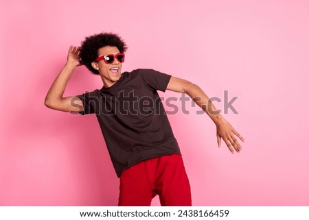 Photo of macho young carefree guy in brown t shirt and red pants stylish expensive cool sunglasses isolated on pink color background