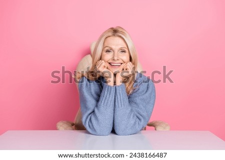 Photo of excited funky woman wear pullover sitting office smiling hands cheeks isolated pink color background