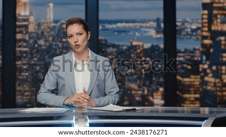 Serious anchor woman talking at newscast modern multimedia channel close up. Confident lady newsreader covering daily news in television studio. Female newscaster ending late night program on tv