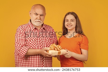 cheerful girl and granddad with present box for anniversary