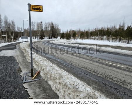 Curving road during the winter, bus stops on both sides