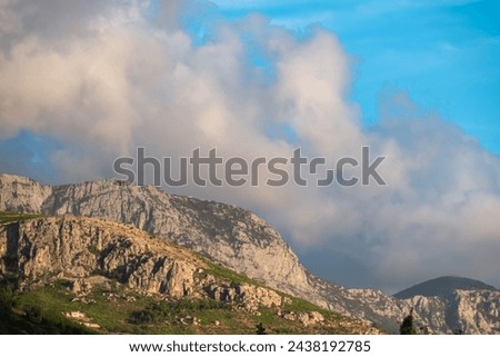 Scenic sunset view of cloud covered Biokovo mountains in majestic Dinaric Alps seen from Makarska, Split-Dalmatia, Croatia, Europe. Coastline of Makarska Riviera. Hiking in the Balkans. Wanderlust Royalty-Free Stock Photo #2438192785