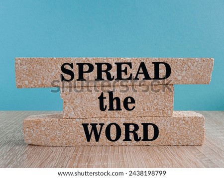 Spread the word symbol. Brick blocks with text Spread the word. Beautiful blue background, wooden table, copy space. Business, motivational concept.
