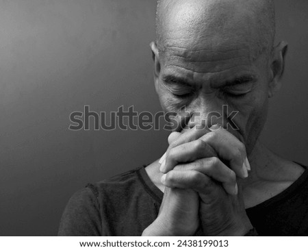 man praying to god with hands together worshiping God Caribbean man praying with people stock image stock photo	