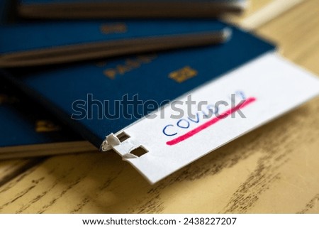 Passport and note with Covid-19 inscription. Coronavirus disease outbreak. Travelling in epidemic period. Passport border control and quarantine of infected tourists. Royalty-Free Stock Photo #2438227207