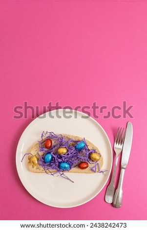Sandwich with hay and Easter eggs in a plate on a pink background.