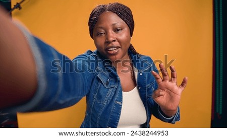 Video captures african american female with positive demeanor, elaborating on courier profession. Young black woman on bike talks about food delivery service while looking directly into the camera. Royalty-Free Stock Photo #2438244953