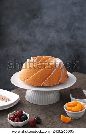 A very delicious and tempting cake served with powdered sugar and fruit