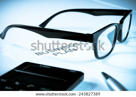 business plan words near glasses, pen and calculator white on table, business concept