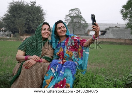 Indian happy rural woman taking selfie picture at agriculture filed.