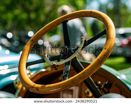 Veteran car wooden steering wheel with a brass engine control lever Royalty-Free Stock Photo #2438290521