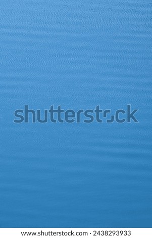Relaxing background of small waves and ripples of vibrant blue water