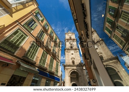 Saint John the Baptist Church in Málaga, Spain. View of St John the Baptist Church from street level with a reflection of the church tower in a window. The Malaga church is in the old town city center Royalty-Free Stock Photo #2438327699