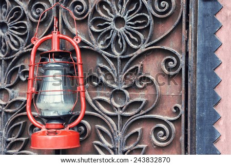 Kerosene lamp on wrought iron gates background