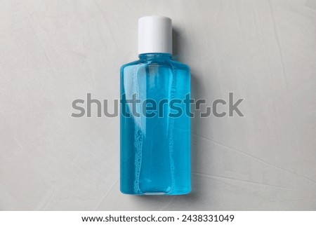 Fresh mouthwash in bottle on grey textured background, top view Royalty-Free Stock Photo #2438331049