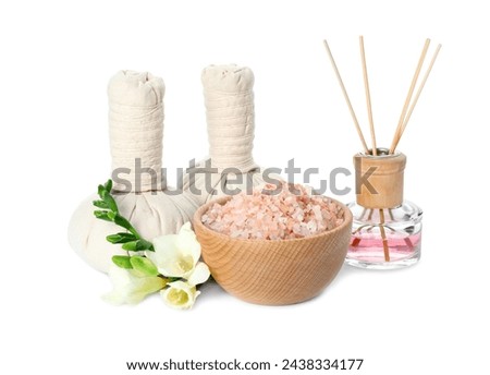 Spa composition. Herbal massage bags, sea salt, reed air freshener and beautiful flowers on white background