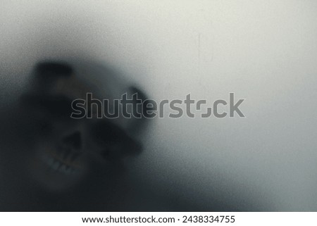 Silhouette of creepy ghost with skull behind cloth, space for text