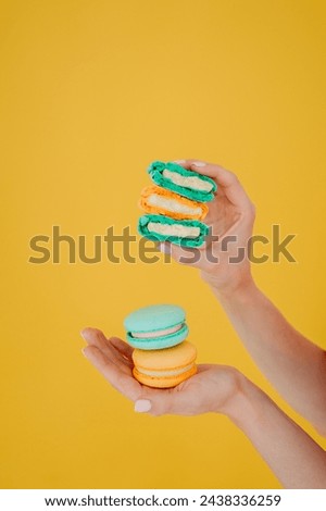 The focus is on the persons hand and the colorful cookies they are holding.