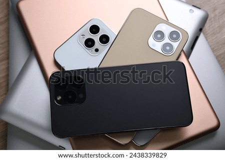 Many different modern gadgets on wooden table, closeup