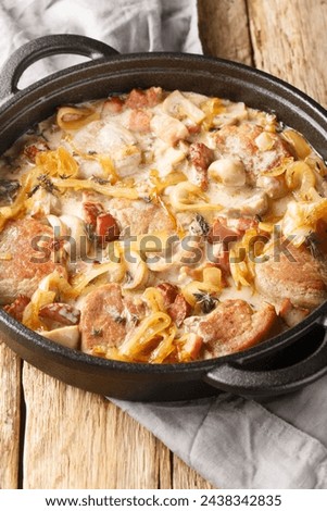 Danish pork tenderloin that is coupled with onions, bacon and mushrooms all doused in a creamy sauce closeup on the pan on the table. Vertical
 Royalty-Free Stock Photo #2438342835