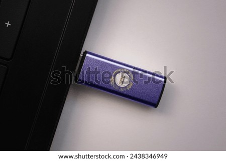 usb flash drive in notebook computer with the national flag of kentucky state on gray background. concept
