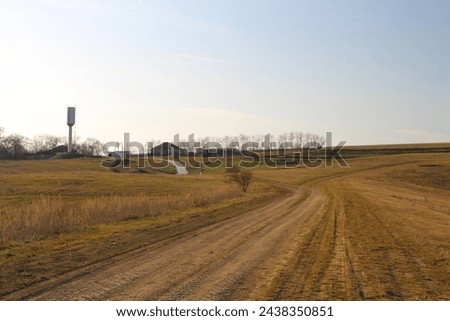 A dirt road with a sign on the side