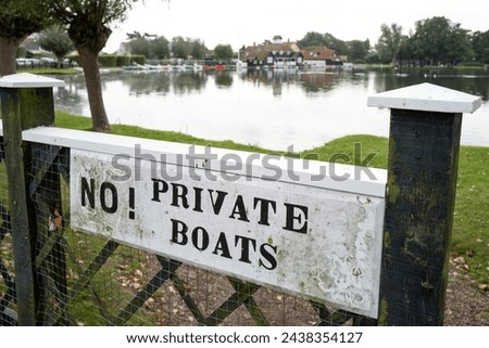 Shallow focus of a No Private Boat sign seen at the entrance to a private lake. The lake has boats for hire for the public and will not allow private vessels.