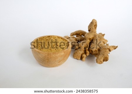 ginger spices and powder in a wooden bowl white background