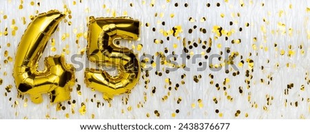 Golden foil balloon number, figure forty-five on white with confetti background. 45th birthday card. Anniversary concept. birthday, new year celebration. banner, copy space.