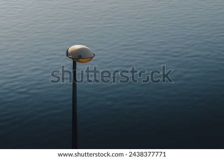 street lamp against a background of water  Royalty-Free Stock Photo #2438377771