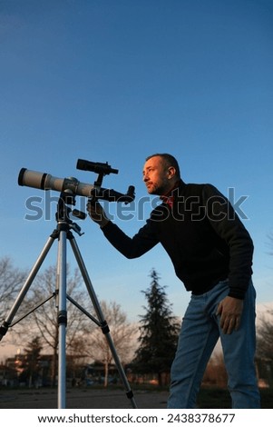 Amateur astronomer observing Sun eclipse and Sun with a telescope and special solar filter. Royalty-Free Stock Photo #2438378677