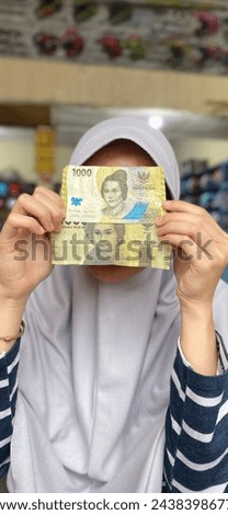 Pic of the difference between the old and the newest one thousand rupiah in Indonesia