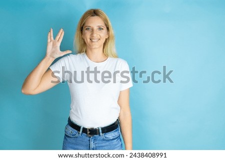 Young beautiful woman wearing casual t-shirt over isolated blue background doing star trek freak symbol