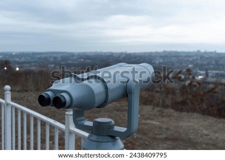 Grey binoculars at the observation deck on a cloudy day